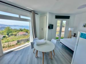 a living room with a white table and a large window at Apartamentos Isla del Santo in Marín