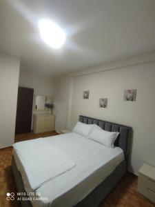 a bedroom with a large white bed in a room at Relax Apartament in Vlorë