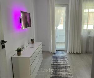 a white room with a dresser and a window at Lisis Premium Apartments in Reşiţa