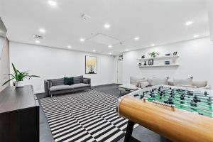 ein Wohnzimmer mit Tischfußball in der Mitte in der Unterkunft Contemporary Designer 2 Bed Apartment, Free Parking, Gym, Yoga & Cinema Room in Bedford