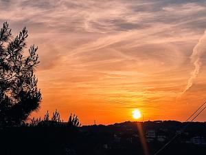 a sunset with the sun in the sky at Anemomilos View in Koskinou
