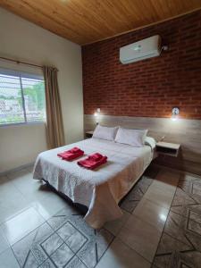 a bedroom with a bed with two red towels on it at 4 Estaciones in Pergamino