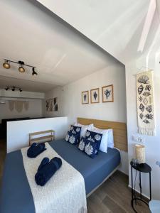 a bedroom with a bed with blue pillows on it at Apartamentos Matilda Conil - Playa in Conil de la Frontera