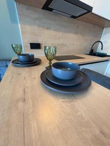 zwei Schüsseln und Gläser auf einem Holztisch in der Unterkunft ЖК Панорама Парк Костанай in Qostanai + 2 Fotos