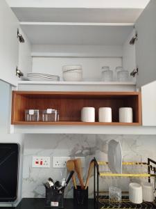 a kitchen with wooden shelves with dishes on it at Kiambu cozy studio in Kiambu