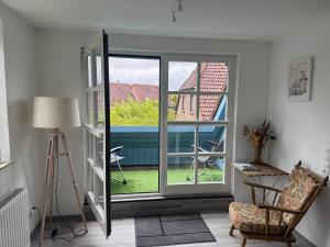 a room with a window and a chair and a lamp at Design Apartment in Carolinensiel in Carolinensiel