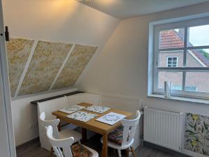 a dining room with a table and chairs and a window at Design Apartment in Carolinensiel in Carolinensiel