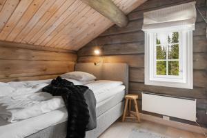a bedroom with a bed in a wooden cabin at Trysilfjell 811, Trysil by Vacation Trysil in Mælem
