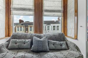 a couch sitting in a room with a large window at Large 4 Bed Town House Ideal for Contractors & Family Friendly in Great Central Location in Plymouth +56 photos