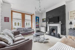 a living room with a couch and a fireplace at Large 4 Bed Town House Ideal for Contractors & Family Friendly in Great Central Location in Plymouth