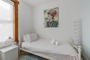 a bedroom with a bed with a painting on the wall at Large 4 Bed Town House Ideal for Contractors & Family Friendly in Great Central Location in Plymouth