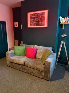 a couch with colorful pillows on it in a room at winslow in Manchester +4 photos