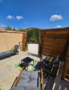 a patio with chairs and a wooden fence at Mini Loft à la campagne La BA-LINE in Entrecasteaux