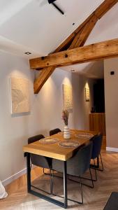 a dining room with a wooden table and chairs at Magnifique appartement centre ville de Besançon in Besançon