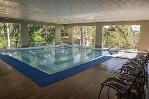 a large swimming pool with chairs in a house at Lagoa Parque Hotel in Lagoa Vermelha