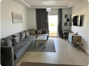 un salon avec un canapé et une table dans l'établissement Appartement avec piscine Imi ouaddar - Family only, à Agadir