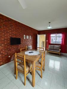 a dining room with a table and chairs and a brick wall at 4 Estaciones in Pergamino