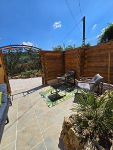 a patio with a fence and a table and chairs at Mini Loft à la campagne La BA-LINE in Entrecasteaux