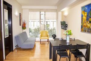 a living room with a dining room table and chairs at Puerta Alameda Suites México in Mexico City