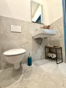 a bathroom with a white toilet and a sink at NEU Golden Apartment Zentrum Goldstadt Pforzheim Schlössle in Pforzheim