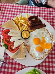 a plate of breakfast food with eggs sausage and french fries at Stari Vuk in Belgrade