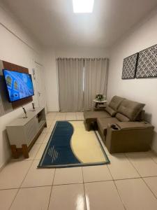 un soggiorno con divano e TV a schermo piatto di Cond Alf Costa ap 01 a Belém