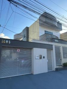 un edificio bianco con porte di garage chiuse di fronte di Cond Alf Costa ap 01 a Belém