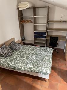 a bedroom with a bed and a desk and shelves at Chambre calme, climatisé, appartement N2 in Avignon