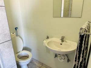 a bathroom with a toilet and a sink at Flat in Khomas Region
