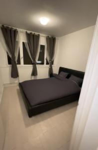 a bedroom with a bed in a room with curtains at Appartement de Myriam in Mons-en-Baroeul