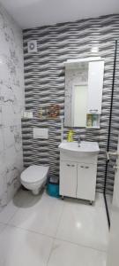 a white bathroom with a toilet and a sink at Apartman Maja 46 in Doboj