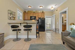 a kitchen and living room with a counter and stools at Heart of Hyde Park Tampa/Parking/Netflix/Gym in Tampa +43 photos