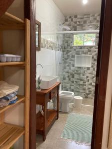a bathroom with a sink and a toilet and a shower at Residencial Casa Laranja - Casas na Praia da Ferrugem in Garopaba