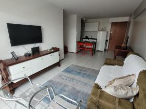 a living room with a couch and a tv in it at Apartamento Ponta Verde in Maceió