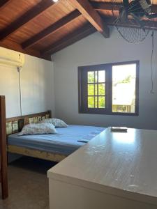 a bedroom with a bed and two windows in it at Residencial Casa Laranja - Casas na Praia da Ferrugem in Garopaba