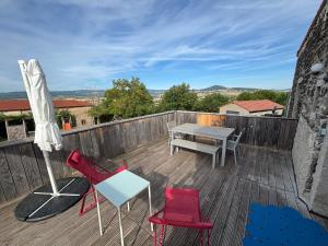 een terras met een tafel en stoelen en een parasol bij Casalleia in Bergonne