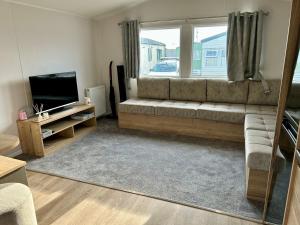 a living room with a couch and a mirror at Blosseys Beach House in South Hayling
