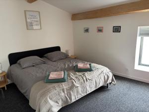 een slaapkamer met een bed met twee kussens erop bij Casalleia in Bergonne