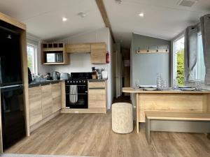 a kitchen with wooden cabinets and a stove top oven at Blosseys Beach House in South Hayling
