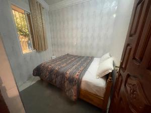 a bedroom with a bed in a room with a window at Résidence Taghazout Oufella by Surf Times in Taghazout