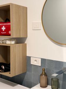 un baño con espejo y lavabo en Appartamento VINESSA - Residence OLIVEA, en Riva del Garda 48 fotos más