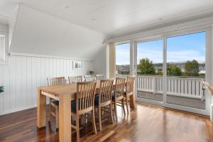 Un comedor con mesa y sillas y un balcón. en Arctic Elegance By Paramount, en Tromsø