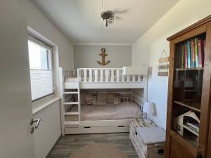 a childs room with two bunk beds and a window at Bungalow-32-100-Schritte-bis-zum-Meer in Staberdorf