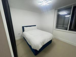 una piccola camera da letto con un letto e una finestra di Spacious Flat for Professional a Slough