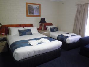 una camera d'albergo con due letti e asciugamani di Poet's Recall Motel a Gundagai