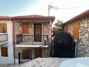 a house with a black gate in front of it at Nils Home in Dhërmi