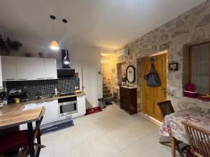 a kitchen with white cabinets and a table and a dining room at Nils Home in Dhërmi