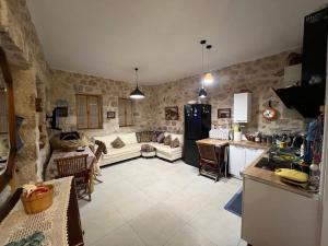 a kitchen and a living room with a couch at Nils Home in Dhërmi