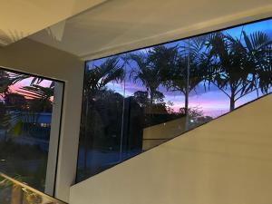 a room with a window with a view of a sunset at COP 30 BELEM - Casa de Luxo - 4 suítes in Marituba
