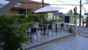 a patio with a table and chairs and an umbrella at Hotel Netuno Beach in Fortaleza